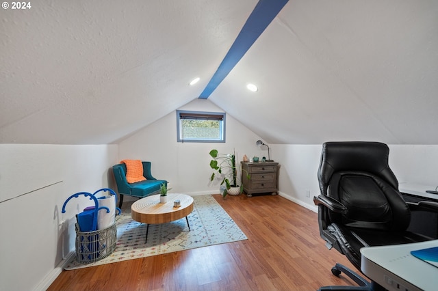 office space featuring a textured ceiling, lofted ceiling, and light wood-type flooring