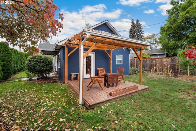 rear view of property featuring a pergola, a yard, and a wooden deck