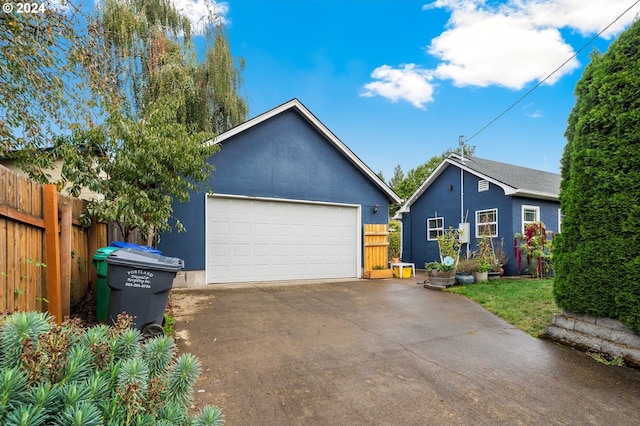 view of front of home with a garage and an outbuilding