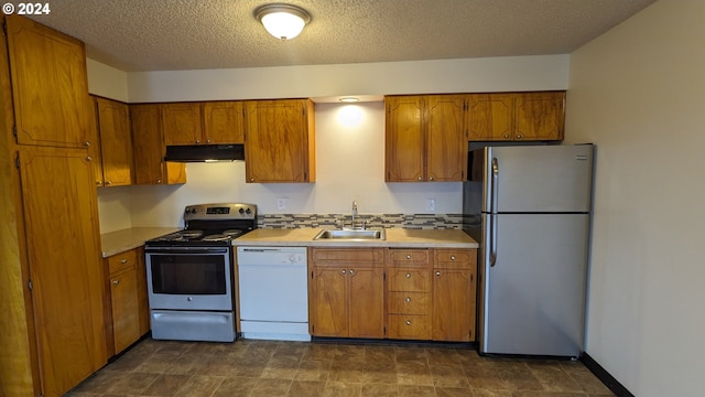 kitchen featuring stainless steel appliances, sink, and a textured ceiling