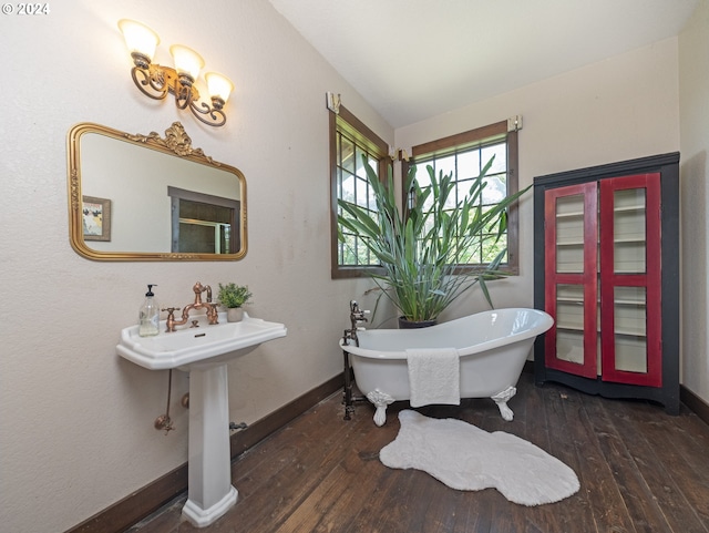 bathroom with hardwood / wood-style flooring, a bathing tub, and lofted ceiling