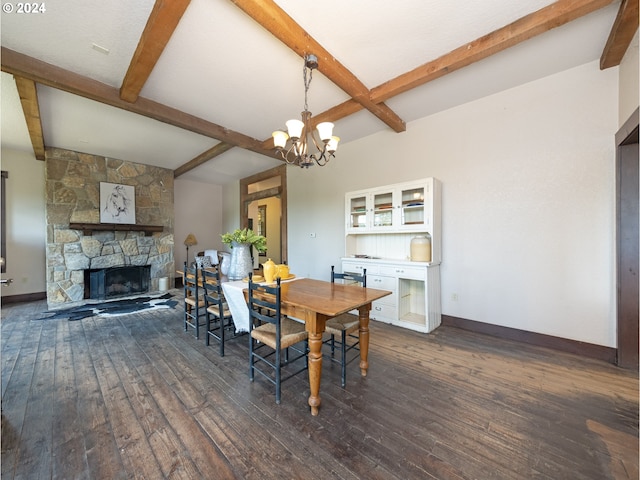 dining space featuring beamed ceiling, a stone fireplace, dark wood-type flooring, and a notable chandelier