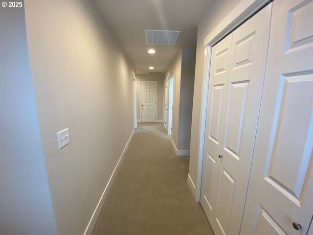 corridor featuring recessed lighting, visible vents, dark carpet, and baseboards