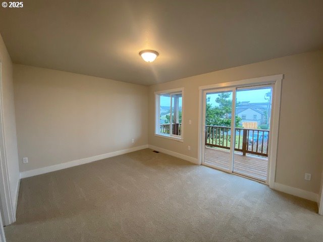 empty room with light carpet and baseboards