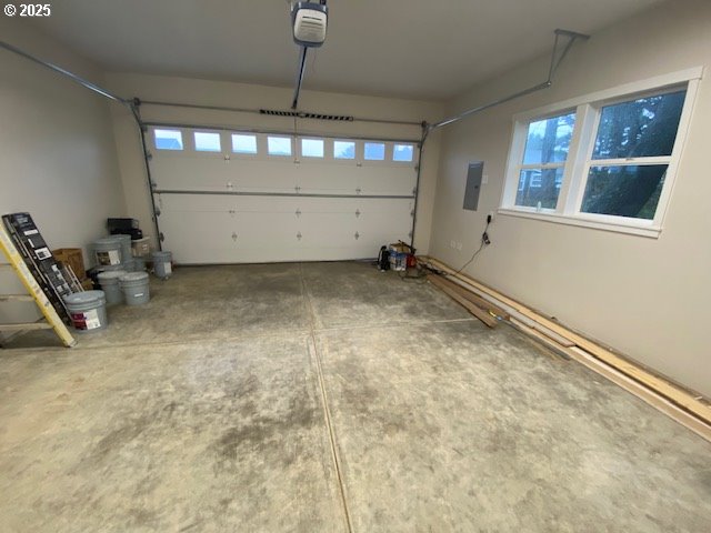 garage with electric panel and a garage door opener