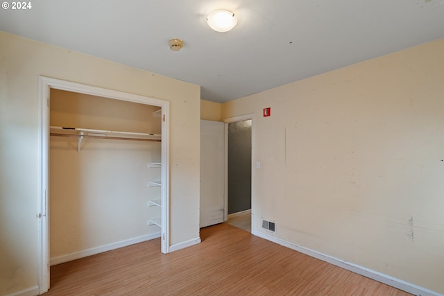 unfurnished bedroom with a closet and light hardwood / wood-style flooring