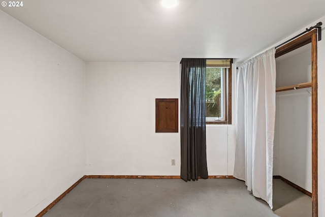 unfurnished bedroom featuring concrete flooring and a closet