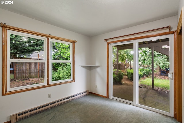 interior space with plenty of natural light, carpet floors, and a baseboard heating unit