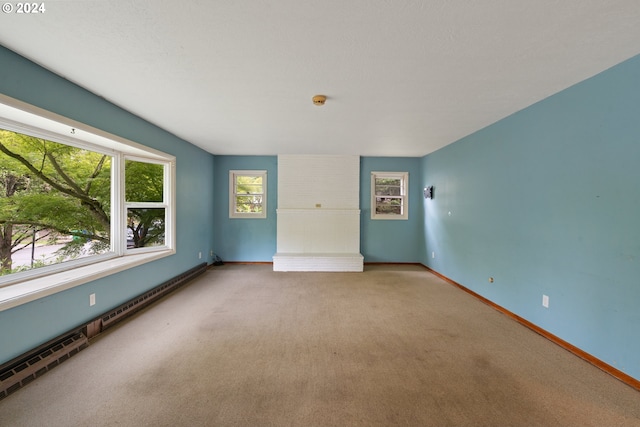 carpeted empty room with a baseboard heating unit