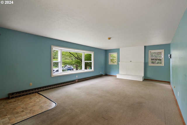 carpeted empty room with a textured ceiling and a baseboard radiator