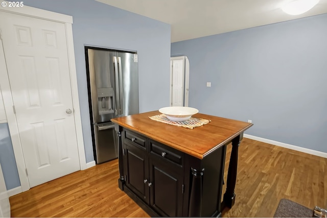 kitchen featuring a kitchen island, light wood-type flooring, and stainless steel fridge with ice dispenser