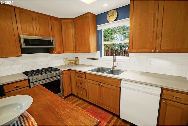 kitchen with decorative backsplash, dark hardwood / wood-style floors, sink, and appliances with stainless steel finishes