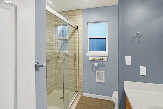 bathroom featuring tile patterned floors, vanity, toilet, and a shower with door