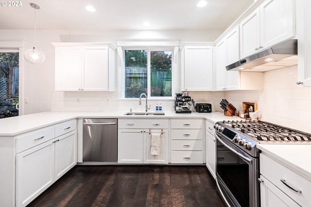 kitchen featuring sink, stainless steel appliances, dark hardwood / wood-style flooring, kitchen peninsula, and pendant lighting