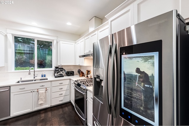 kitchen featuring sink, dark hardwood / wood-style floors, appliances with stainless steel finishes, tasteful backsplash, and white cabinetry