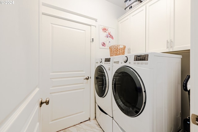 washroom featuring cabinets and washing machine and clothes dryer