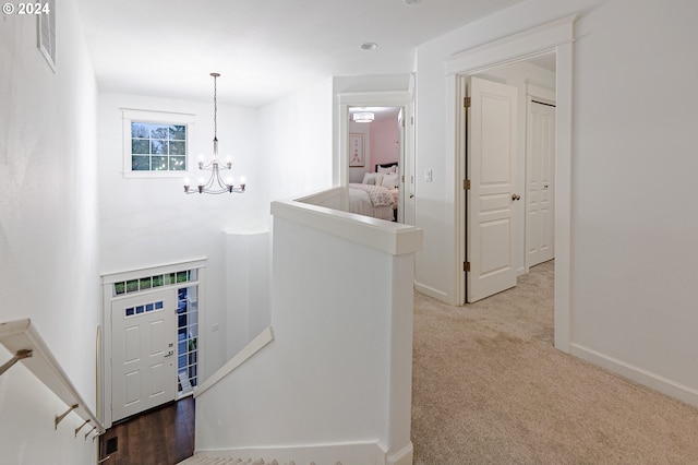 hall featuring a chandelier and light colored carpet