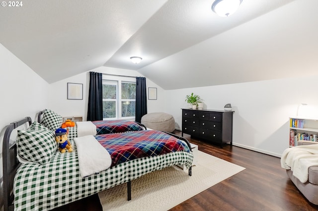 bedroom with dark hardwood / wood-style floors, lofted ceiling, and a textured ceiling