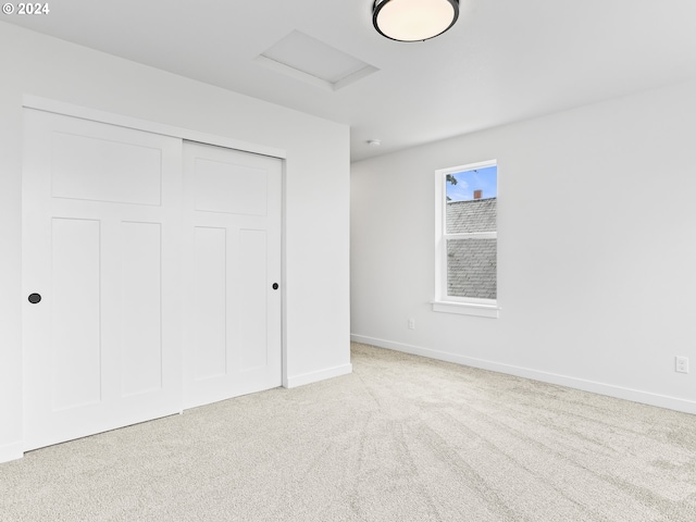 unfurnished bedroom with light carpet and a closet