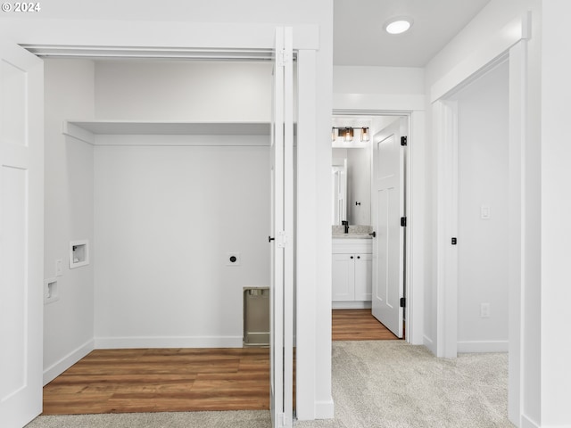 laundry area with hookup for an electric dryer, light hardwood / wood-style floors, and washer hookup