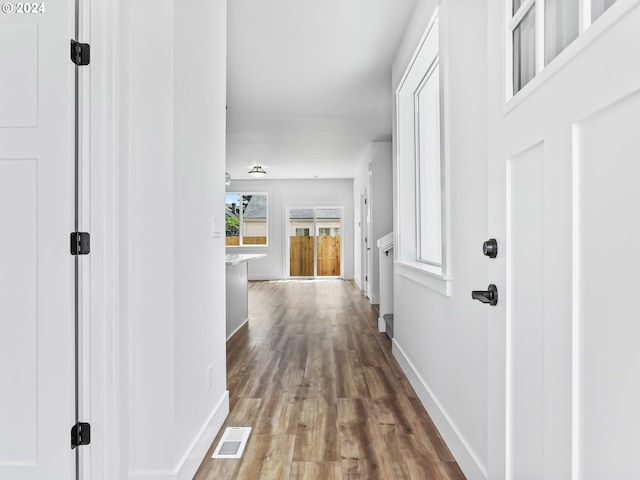 corridor with hardwood / wood-style flooring