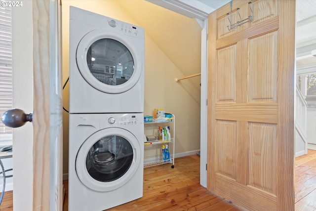 washroom with hardwood / wood-style floors and stacked washer and dryer