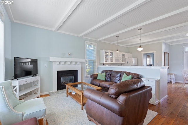 living room featuring beamed ceiling and hardwood / wood-style flooring