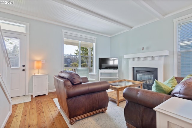 living room with light hardwood / wood-style flooring and beamed ceiling