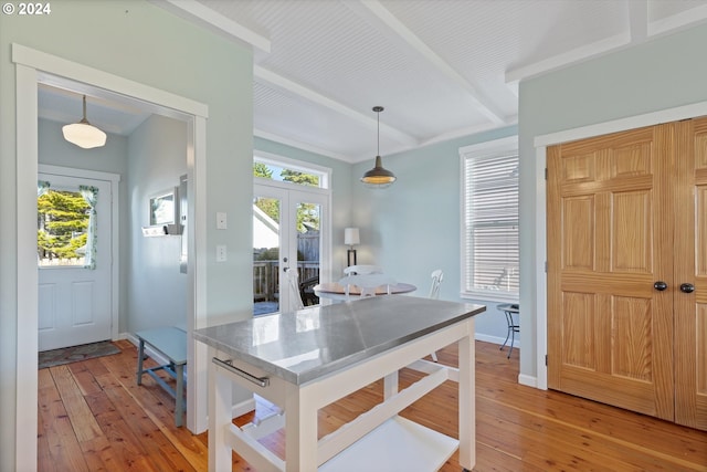 kitchen featuring french doors, beam ceiling, light hardwood / wood-style flooring, and decorative light fixtures