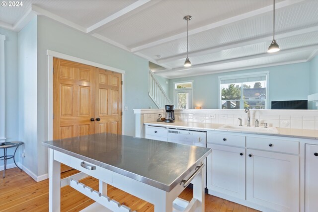 kitchen featuring beamed ceiling, light hardwood / wood-style flooring, sink, decorative light fixtures, and white cabinetry