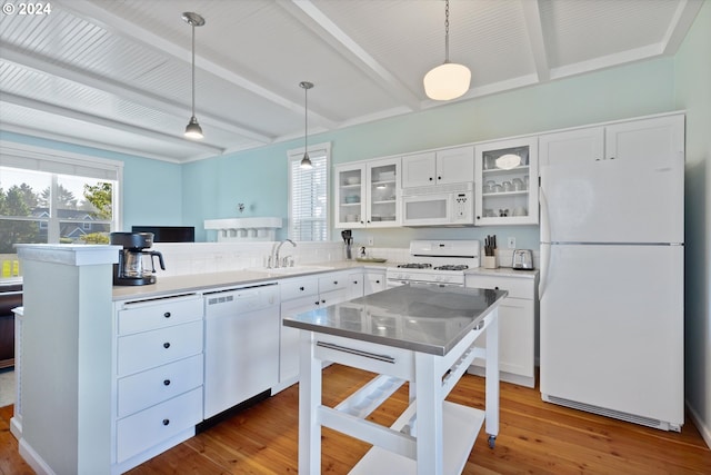 kitchen featuring white appliances, wood-type flooring, sink, hanging light fixtures, and white cabinetry