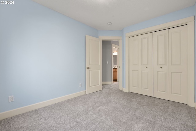 unfurnished bedroom with a closet and light carpet