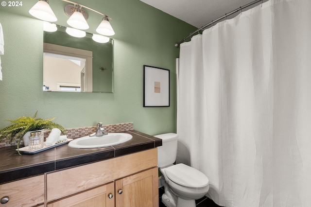 bathroom featuring a textured ceiling, curtained shower, vanity, and toilet