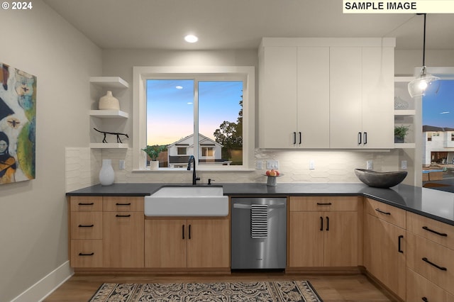 kitchen featuring dishwasher, hanging light fixtures, sink, and backsplash