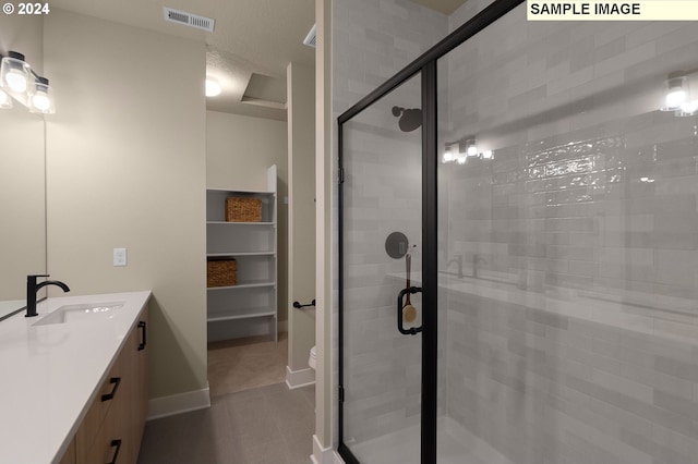 bathroom featuring vanity, a textured ceiling, toilet, and a shower with door