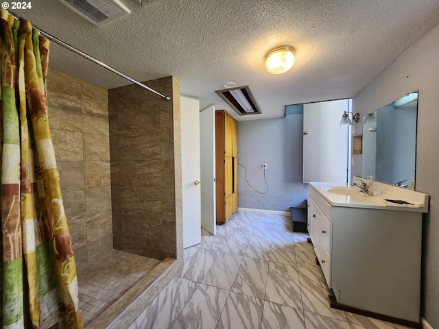 bathroom featuring vanity, a textured ceiling, and walk in shower