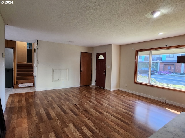 unfurnished living room with hardwood / wood-style floors and a textured ceiling