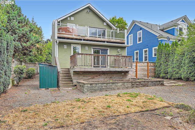 rear view of house with a balcony, fence, a storage unit, and an outdoor structure