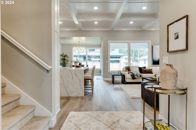 living room with light hardwood / wood-style flooring, a wealth of natural light, beam ceiling, and coffered ceiling