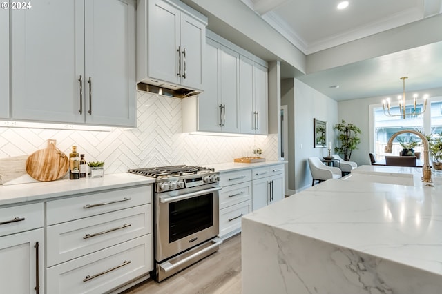 kitchen with sink, tasteful backsplash, white cabinetry, high end stainless steel range oven, and light stone countertops