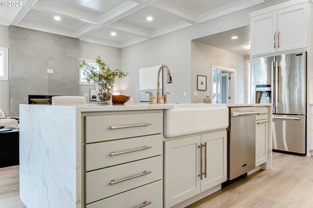 kitchen with stainless steel appliances, white cabinets, and light wood-type flooring