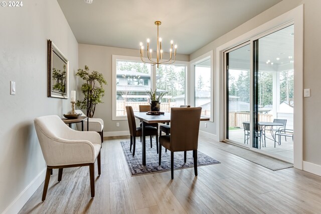 dining room with light hardwood / wood-style flooring and an inviting chandelier