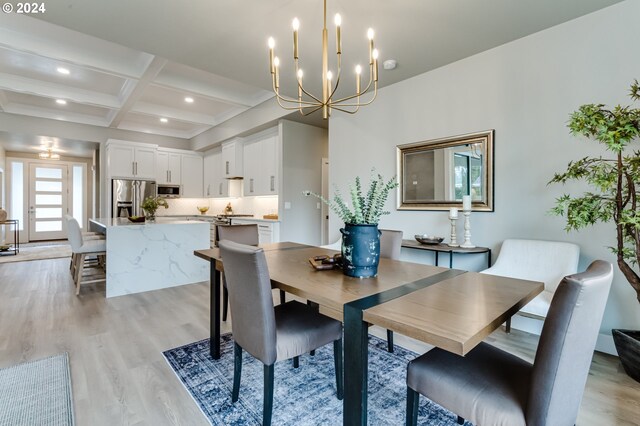 dining room with an inviting chandelier, beam ceiling, light hardwood / wood-style floors, and coffered ceiling