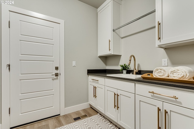 washroom featuring light wood-type flooring and sink