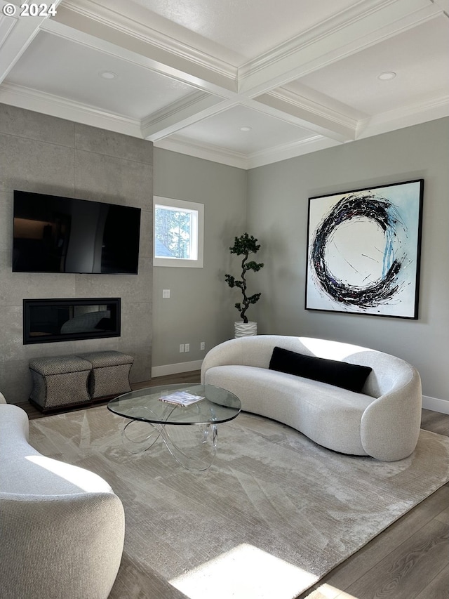 living room with crown molding, beam ceiling, a large fireplace, and hardwood / wood-style flooring