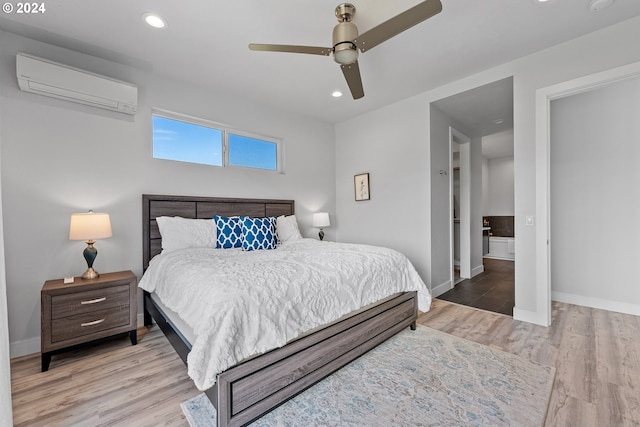 bedroom with light hardwood / wood-style floors, ceiling fan, and a wall mounted AC