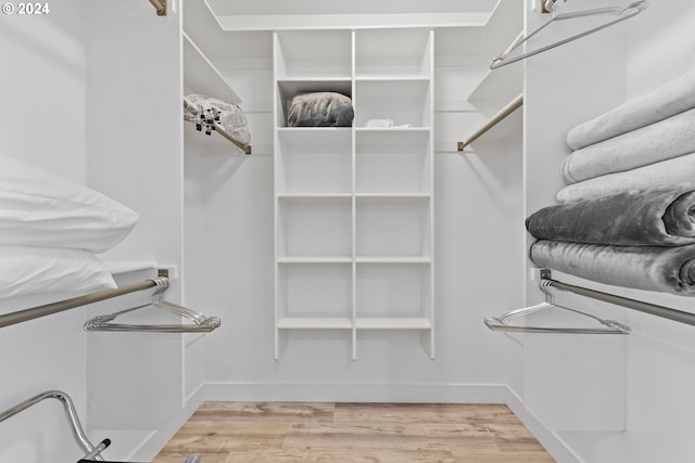 walk in closet with light hardwood / wood-style floors