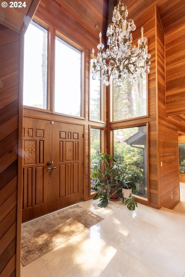 foyer entrance featuring a high ceiling and wood walls