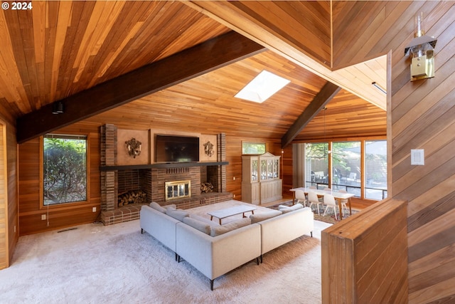 living room featuring a brick fireplace, a healthy amount of sunlight, light colored carpet, and wooden walls