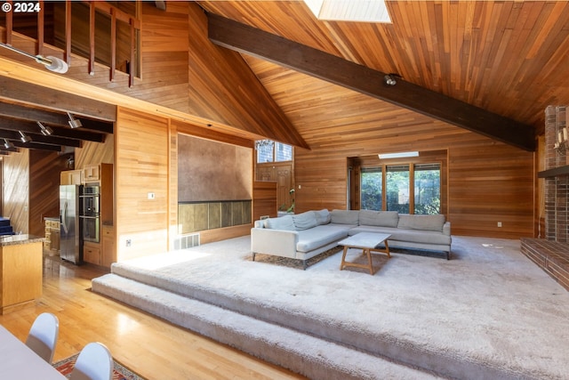 living room featuring wood ceiling, wooden walls, a skylight, and beam ceiling